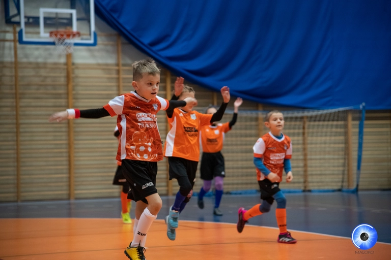 Młodzi zawodnicy podczas dynamicznej rozgrzewki na hali w Raszkowie